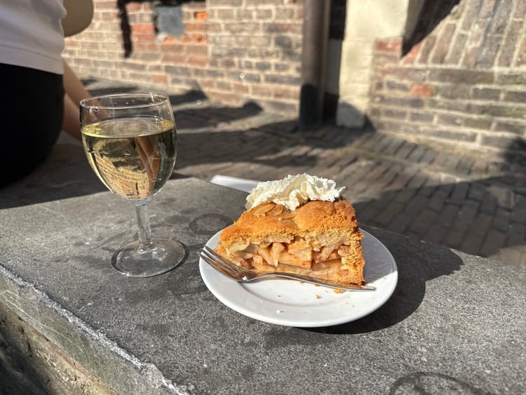 A piece of apple pie and a glass of white wine