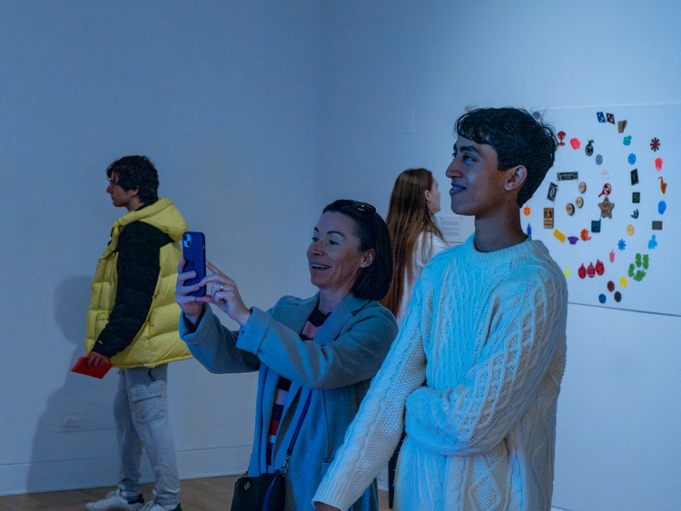 Attendees being bathed in the light of the Sign.
