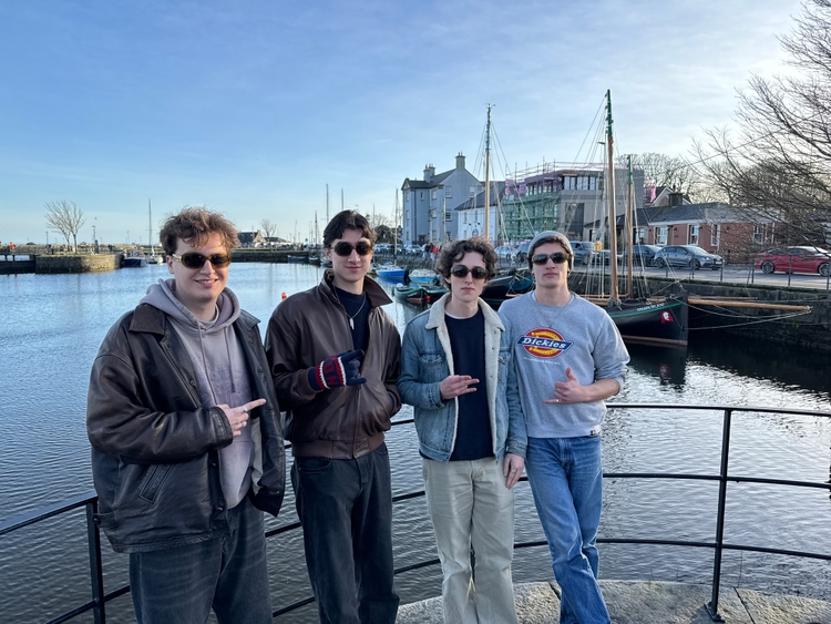Max, Zack, Tom, and Mo standing in front of the river
