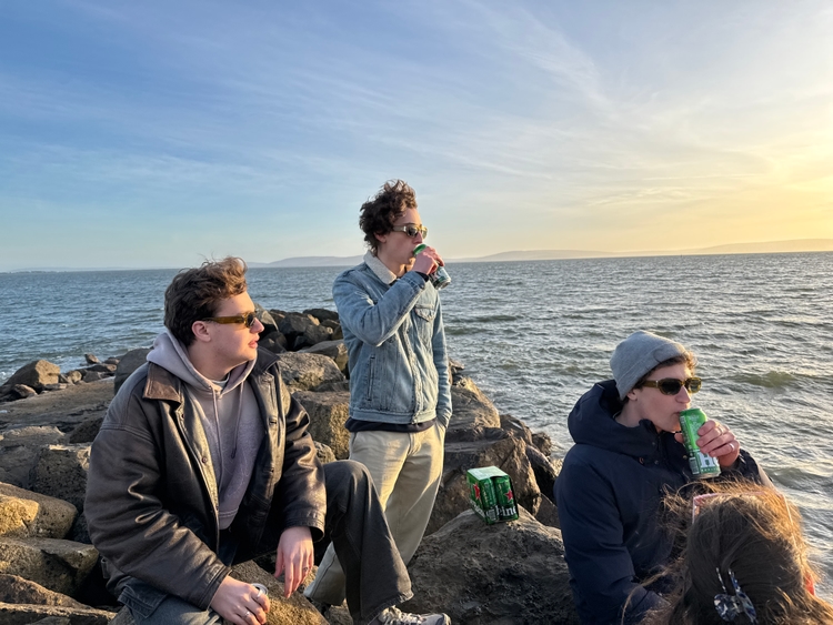 Max, Tom, and Mo on some rocks looking at the sunset