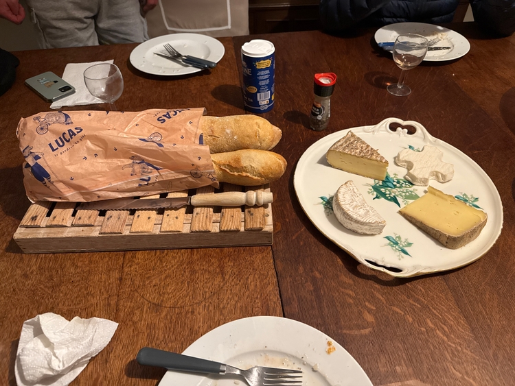 A bread and cheese platter with four different types of cheese