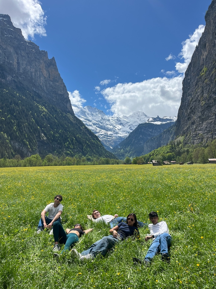 Adam, Nadia, Me, Kate, and Aditya laying in a field in a valley