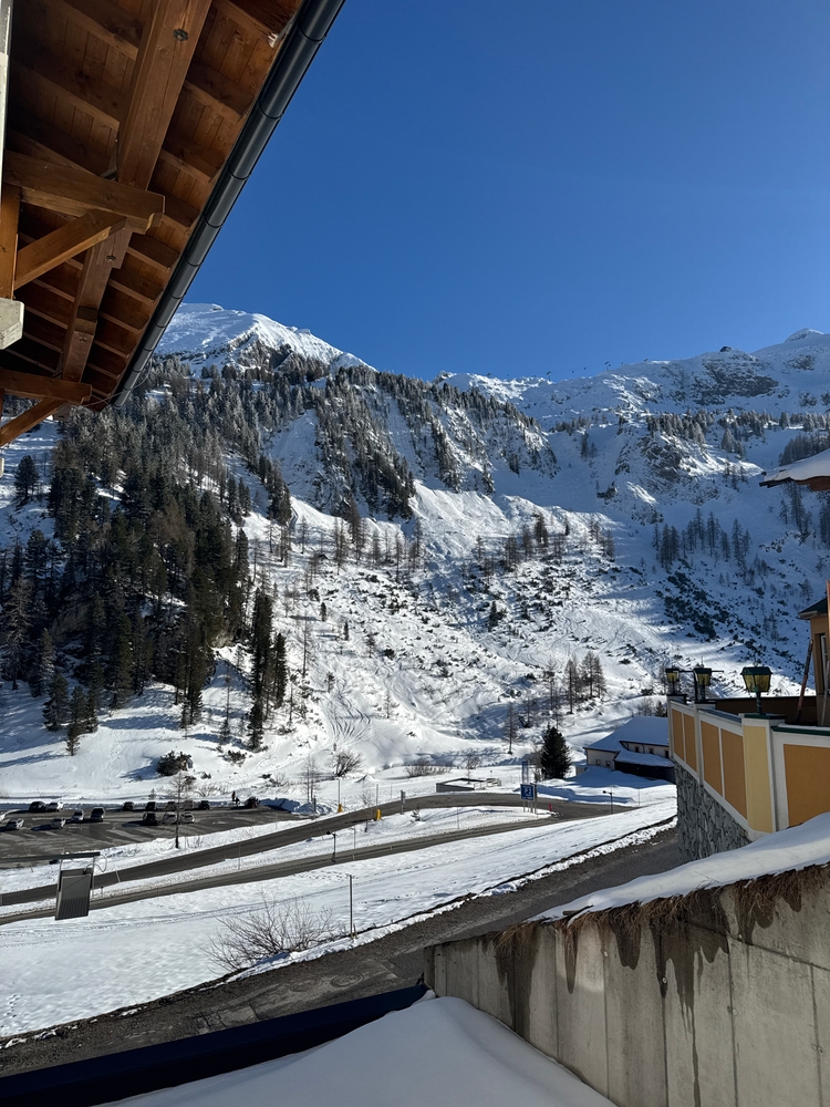 A view from a hotel room with the roof peeking in and a mountain in the foreground