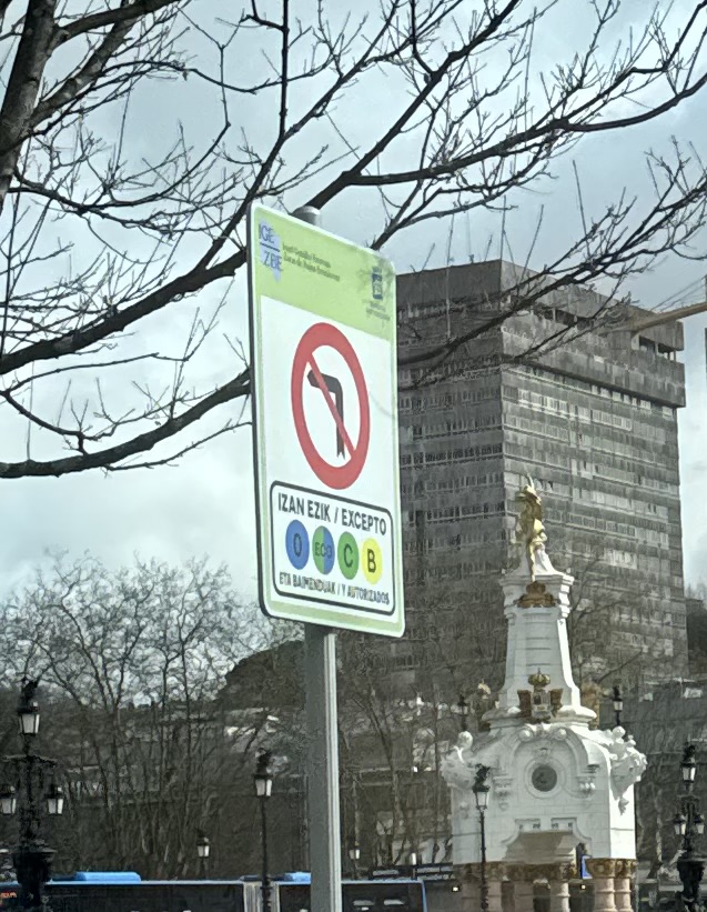 A no left turn except at certain times sign with Basque written first