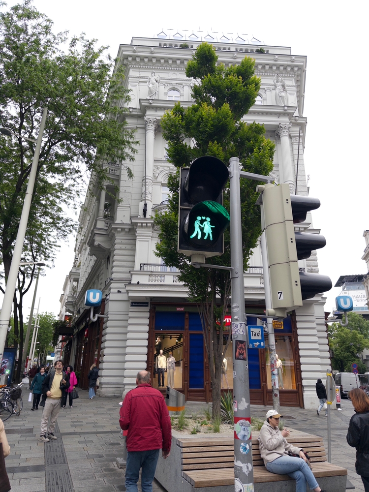 A green pededstrian signal with two people holding hands